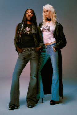 Displays a model wearing the Light wash 'juicy' branded low rise flared embodied jeans 