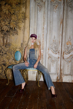 Displays a model wearing the Mid Wash 'Juicy' branded Sand Stud Moto Bootcut Jeans