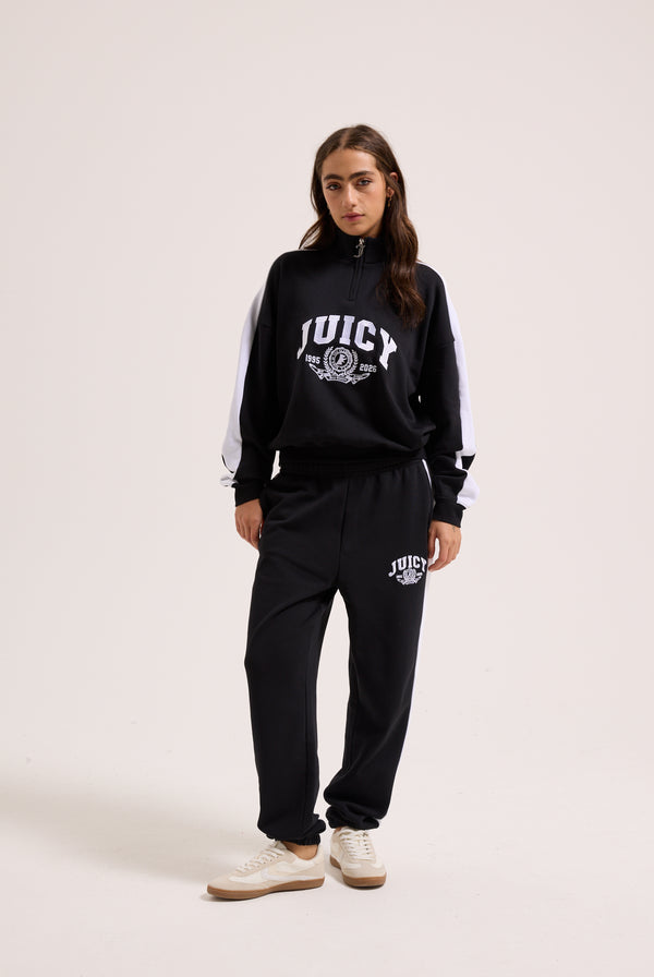 Displays a model wearing the Black 'Juicy' branded college crest track top 