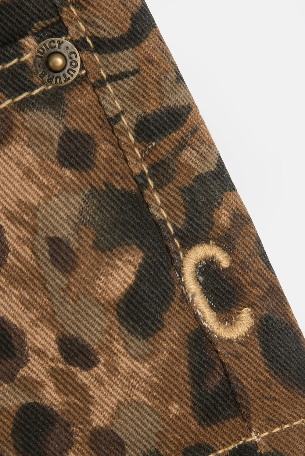 Displays the animal 'Juicy' branded denim lace up shorts featuring the close up on the branding 