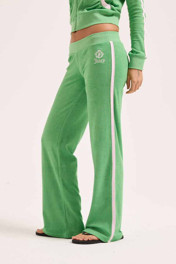 Displays a model wearing the peppermint appliqué 'Juicy' branded Terry ultra low track pants 