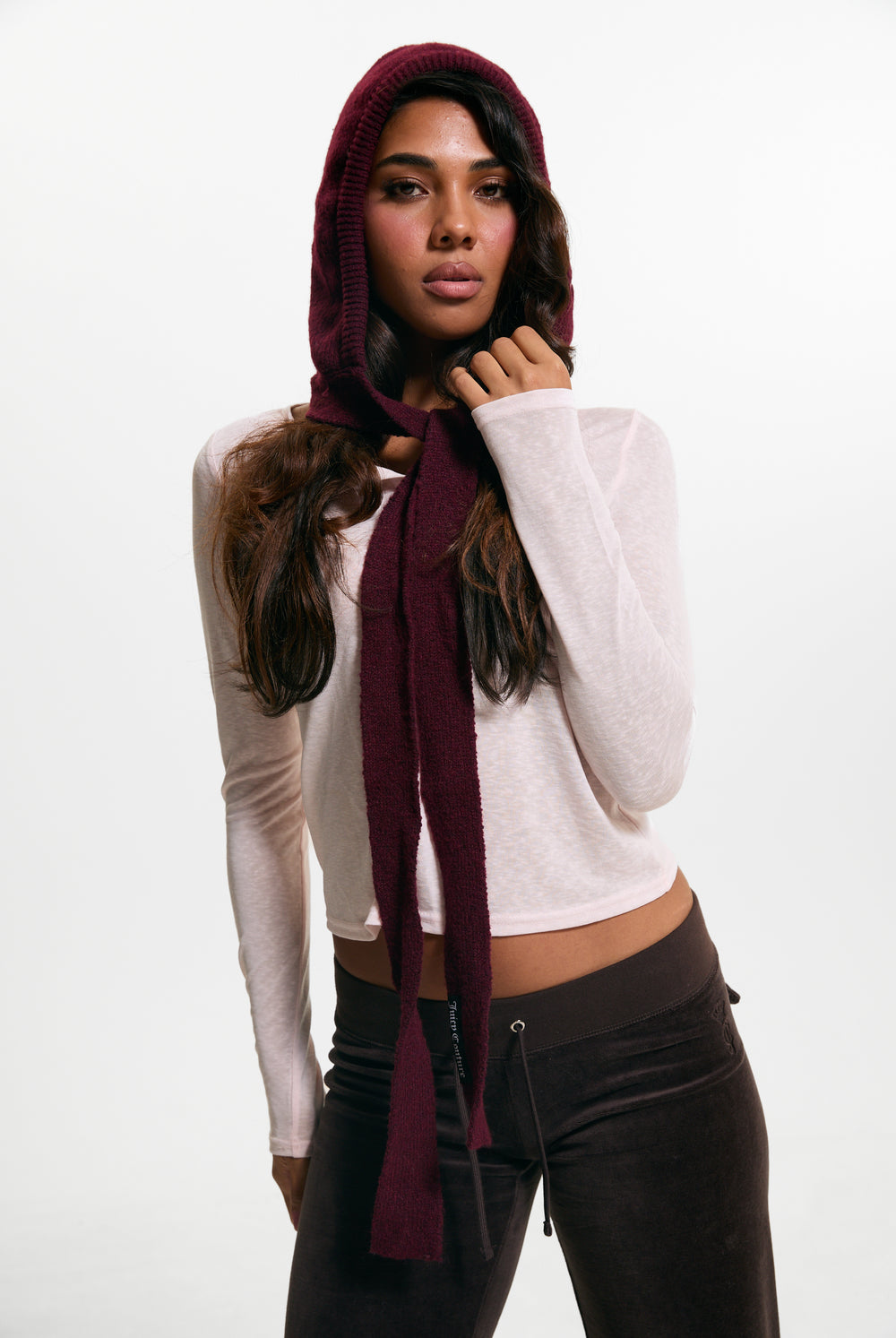 Displays a model wearing the Burgundy 'Juicy' branded Bonnet With Bow