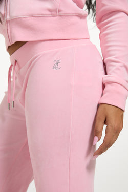 Displays a model wearing the Juicy Pink 'Juicy' branded bridesmaid classic velour low rise track pants 