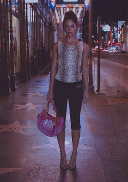 Displays a model wearing the natural cheetah print 'Juicy' off the shoulder top 
