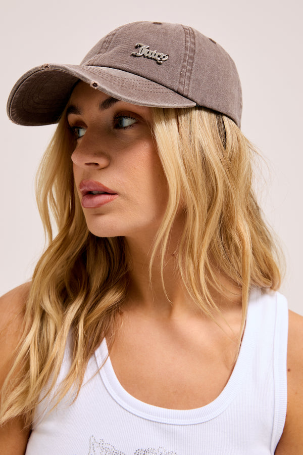 Displays a model wearing the Java 'Juicy' branded distressed cotton denim cap      