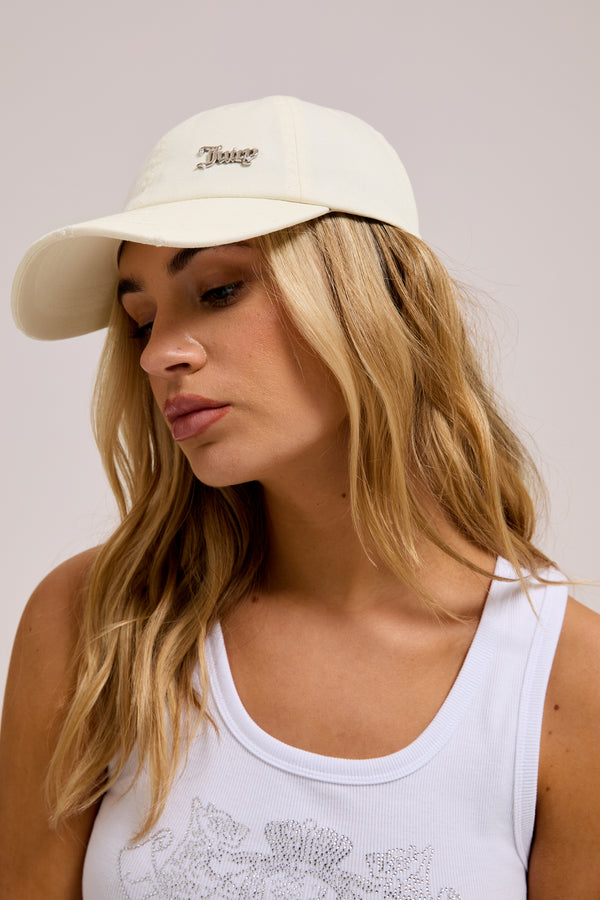 Displays a model wearing the Ecru distressed 'Juicy' branded cotton denim cap 