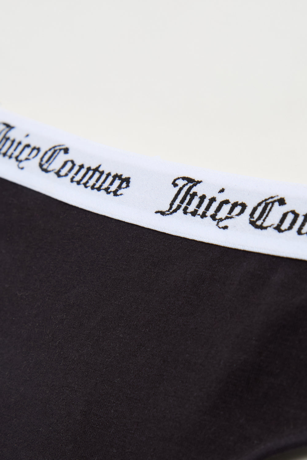 Displays the black 'Juicy' branded Cotton Branded Waistband Thongs included in the Multi Pack featuring the juicy Couture branding 