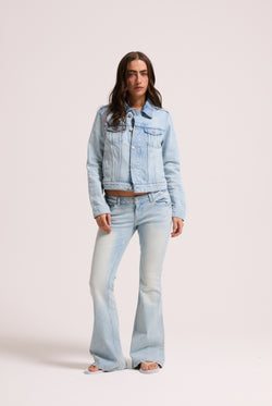 Displays a model wearing the light wash 'Juicy' branded Diamanté low rise flare jeans 