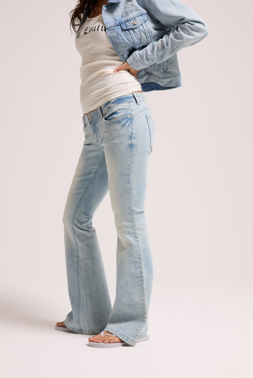 Displays a model wearing the light wash 'Juicy' branded Diamanté low rise flare jeans 