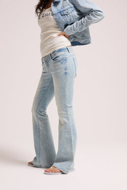 Displays a model wearing the light wash 'Juicy' branded Diamanté low rise flare jeans 