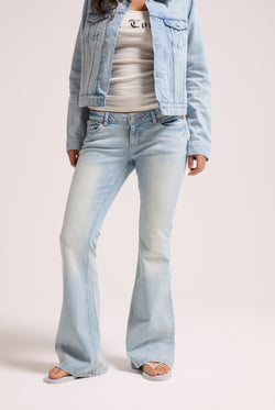 Displays a model wearing the light wash 'Juicy' branded Diamanté low rise flare jeans 