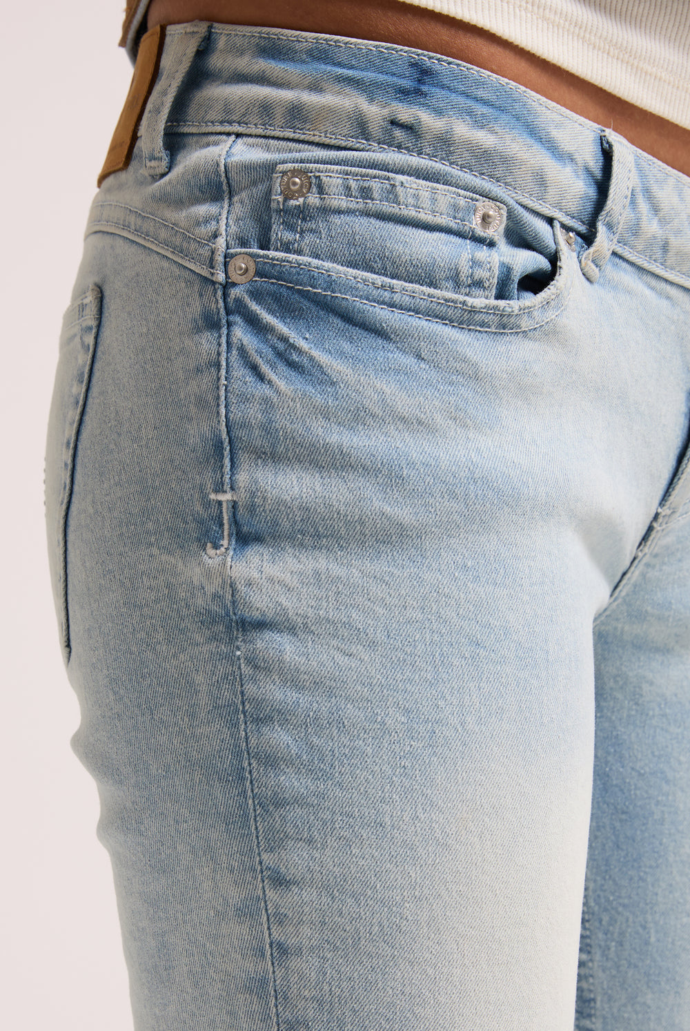 Displays a model wearing the light wash 'Juicy' branded Diamanté low rise flare jeans 