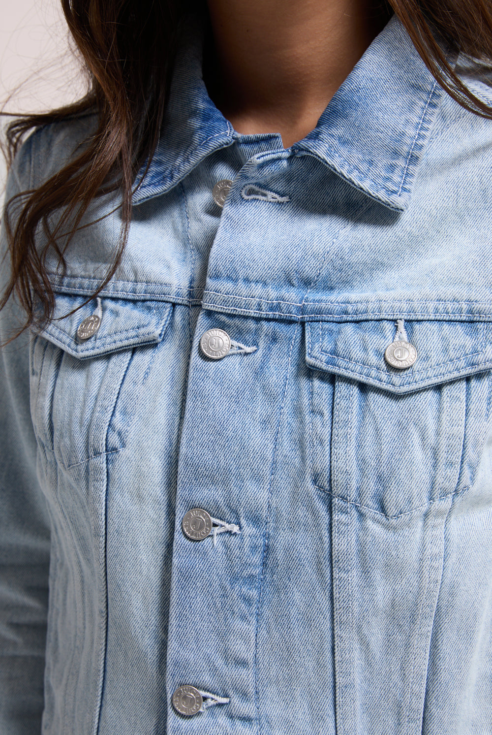 Displays a model wearing the light wash 'Juicy' branded stretch denim fitted jacket