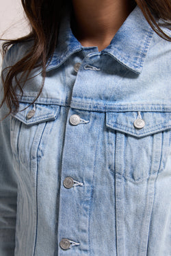 Displays a model wearing the light wash 'Juicy' branded stretch denim fitted jacket