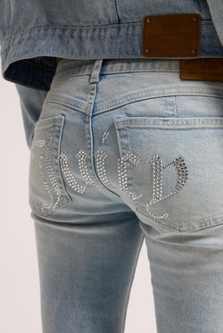 Displays a model wearing the light wash 'Juicy' branded Diamanté low rise flare jeans featuring the juicy branding 
