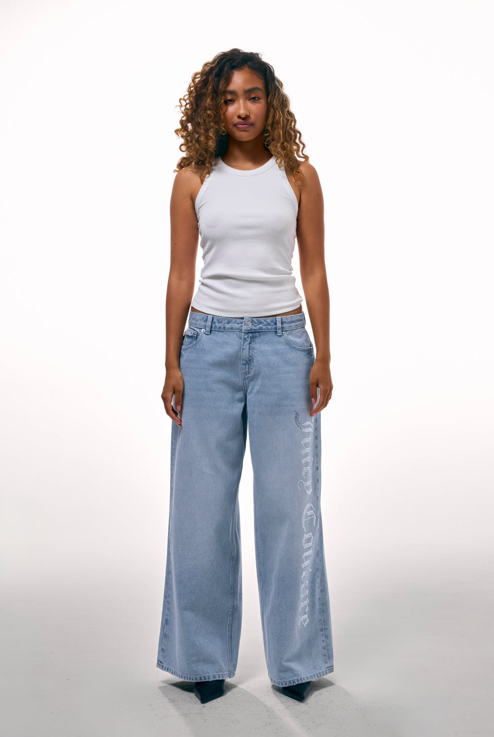 Displays a model wearing the Light Wash Diamanté 'Juicy' branded wide leg jeans 
