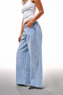 Displays a model wearing the Light Wash Diamanté 'Juicy' branded wide leg jeans 