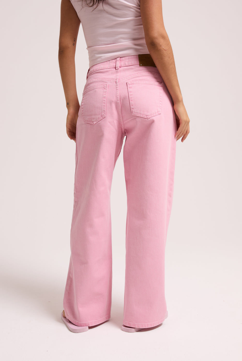 Displays a model wearing the Pink Wash 'Juicy' branded Diamanté wide leg jeans 