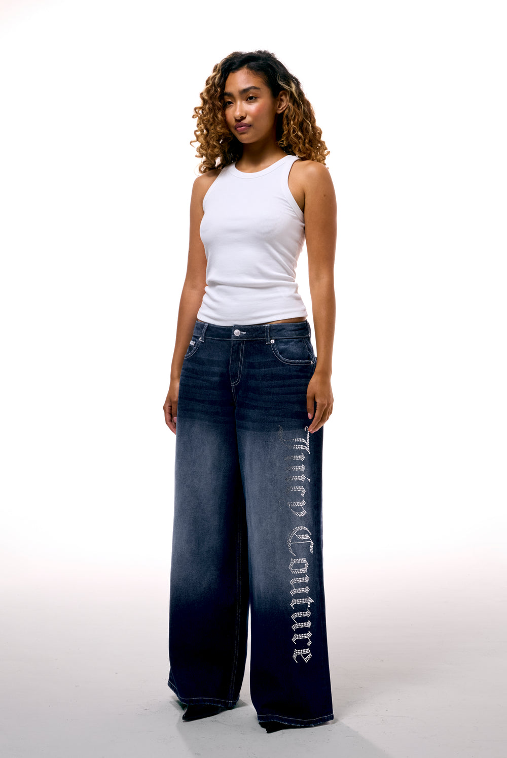 Displays a model wearing the mid Wash 'Juicy' branded wide leg Diamanté jeans 