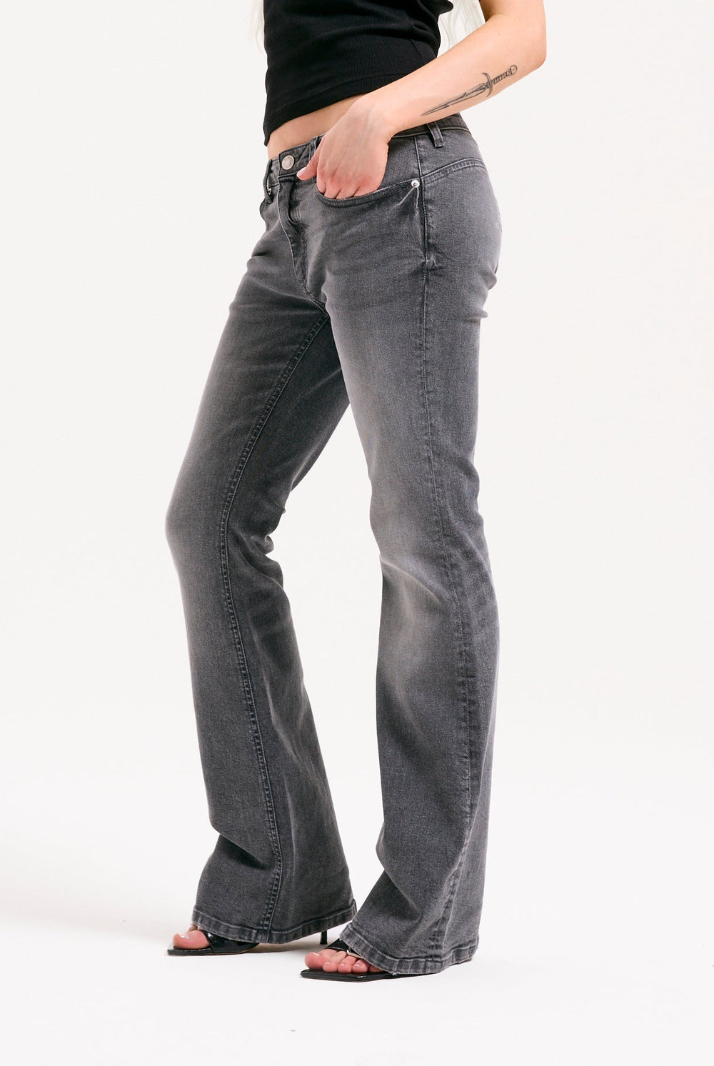 Displays a model wearing the grey wash 'Juicy' branded Digi diamanté mid rise flared jeans 