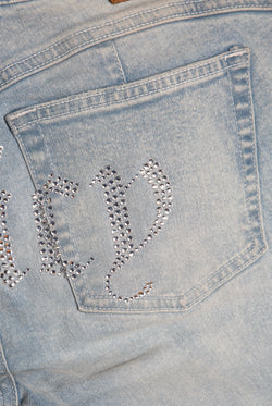 Displays he light wash 'Juicy' branded Diamanté low rise flare jeans featuring the juicy branding