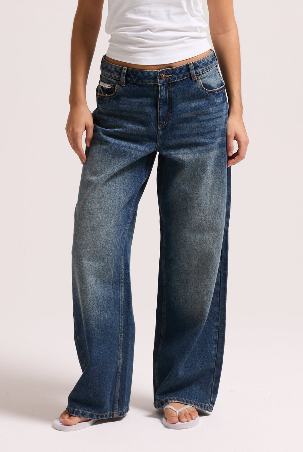 Displays a model wearing the vintage wash mid rise wide leg 'Juicy' branded jeans 