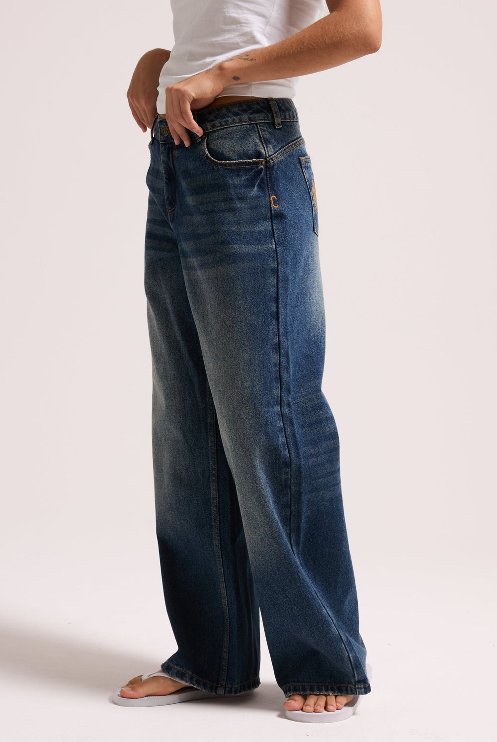 Displays a model wearing the vintage wash mid rise wide leg 'Juicy' branded jeans 