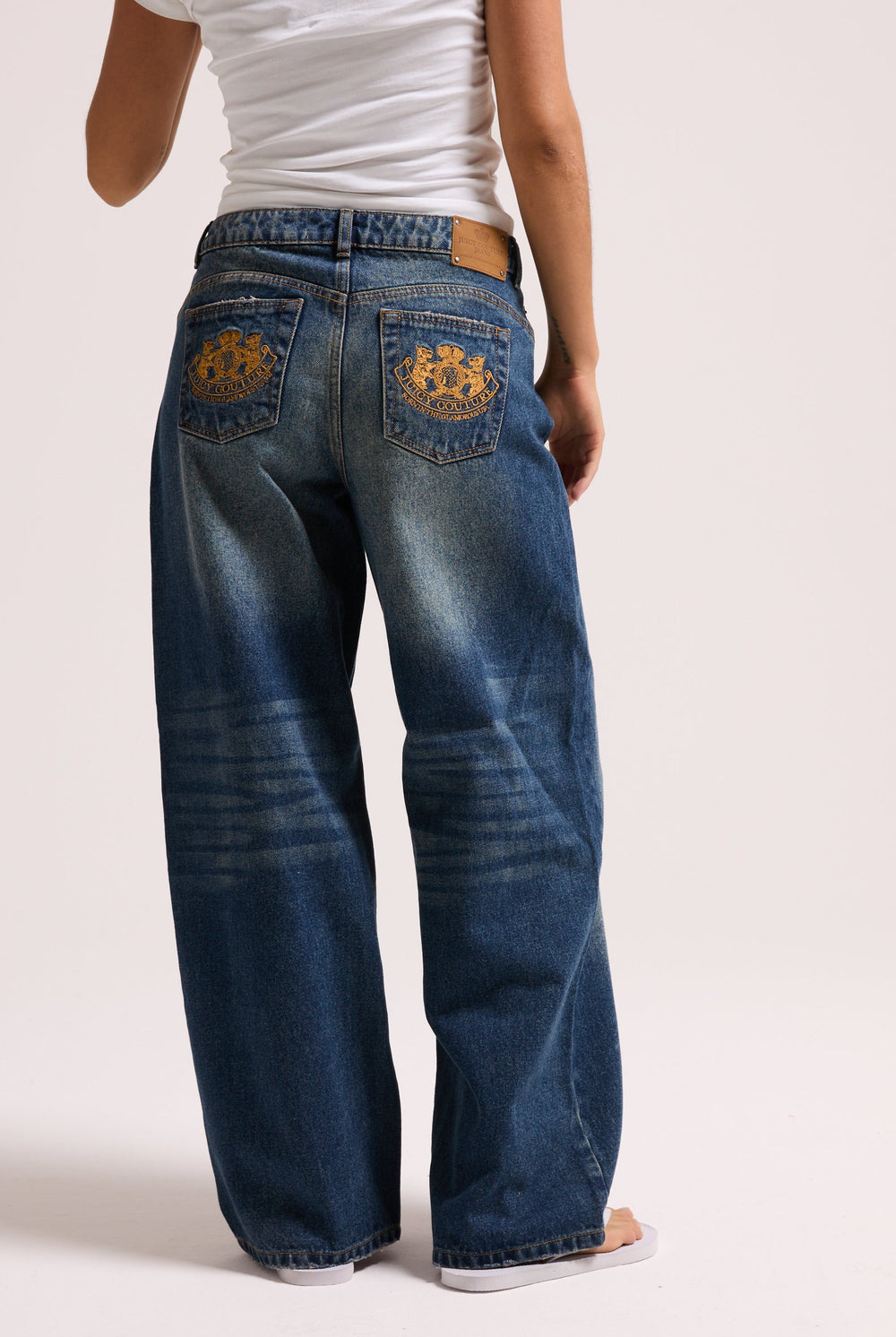 Displays a model wearing the vintage wash mid rise wide leg 'Juicy' branded jeans 