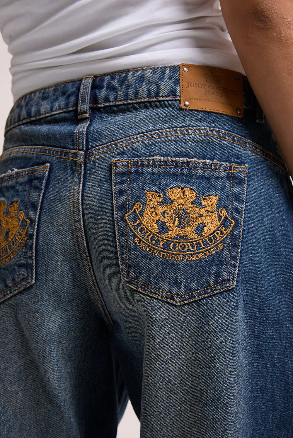 Displays a model wearing the vintage wash mid rise wide leg 'Juicy' branded jeans 
