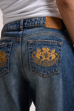 Displays a model wearing the vintage wash mid rise wide leg 'Juicy' branded jeans 