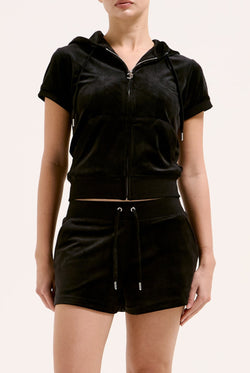 Displays a model wearing the Black 'Juicy' branded classic velour track short with back pocket 