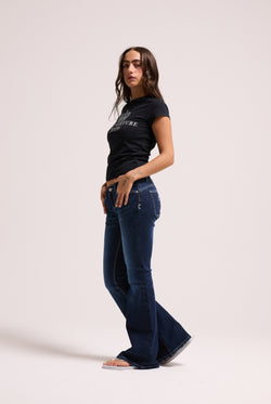 Displays a model wearing the 'Juicy' branded mid wash diamanté low rise flare jeans 