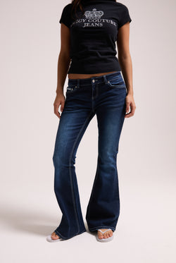 Displays a model wearing the 'Juicy' branded mid wash diamanté low rise flare jeans 