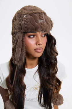 Displays a model wearing the Java 'Juicy' branded Cable Knit Trapper With Fur Lining