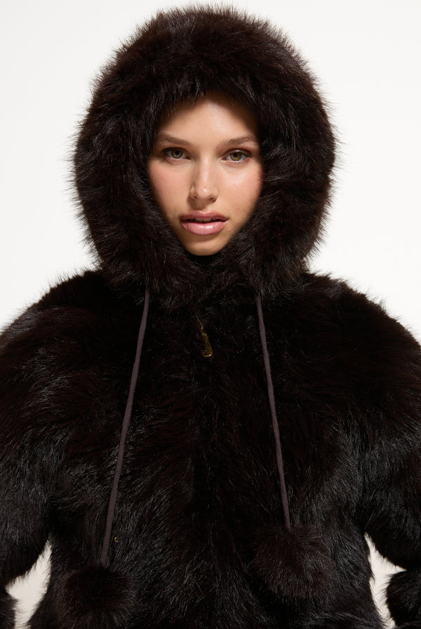 Displays a model wearing the Java 'Juicy' branded Hooded Faux Fur Jacket