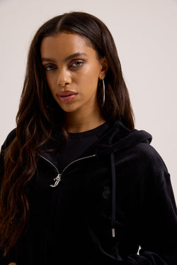 Displays a model wearing the black classic 'Juicy' branded velour oversized hoodie