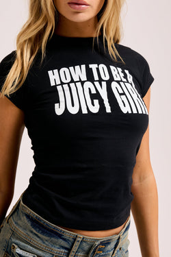 Displays a model wearing the Black 'Juicy' branded HOW TO BE A JUICY GIRL T-SHIRT