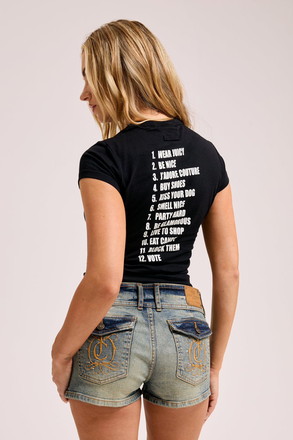 Displays a model wearing the Black 'Juicy' branded HOW TO BE A JUICY GIRL T-SHIRT