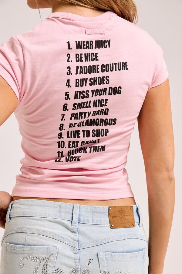 Displays a model wearing the Juicy Pink 'Juicy' branded HOW TO BE A JUICY GIRL T-Shirt