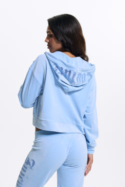 Displays a model wearing the Powder Blue 'Juicy' branded Old Gothic Oversized Cropped Hoodie 