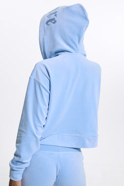 Displays a model wearing the Powder Blue 'Juicy' branded Old Gothic Oversized Cropped Hoodie 