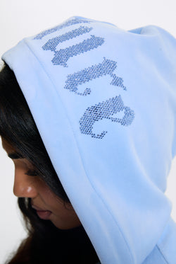 Displays a model wearing the Powder Blue 'Juicy' branded Old Gothic Oversized Cropped Hoodie 