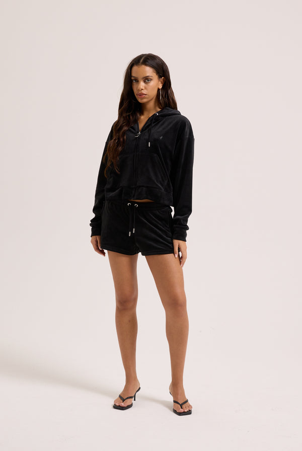 Displays a model wearing the Black outline 'Juicy' branded diamanté oversized cropped hoodie 