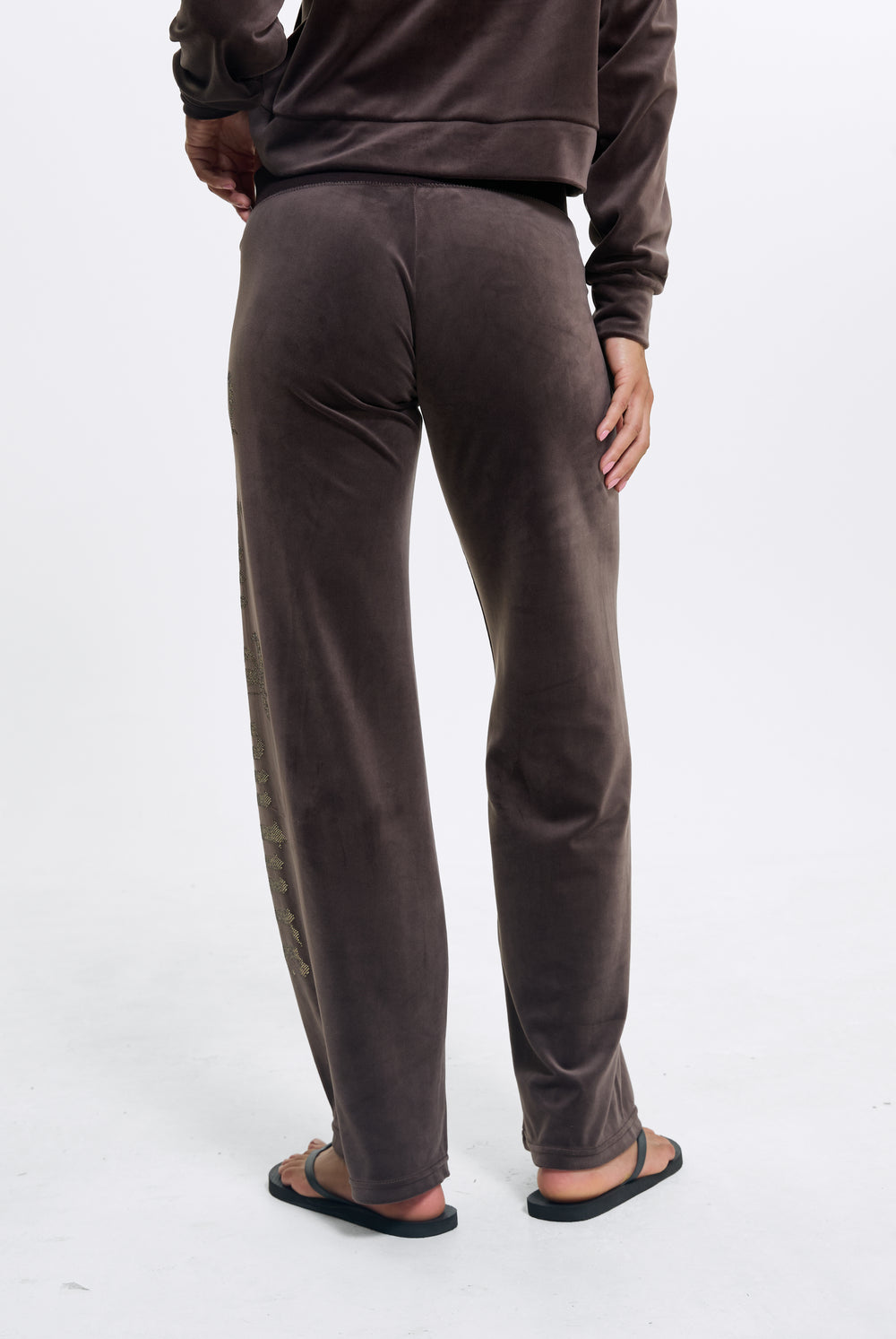 Displays a model wearing the Java 'Juicy' branded Old Gothic Diamante Og Straight Leg Trackpant
