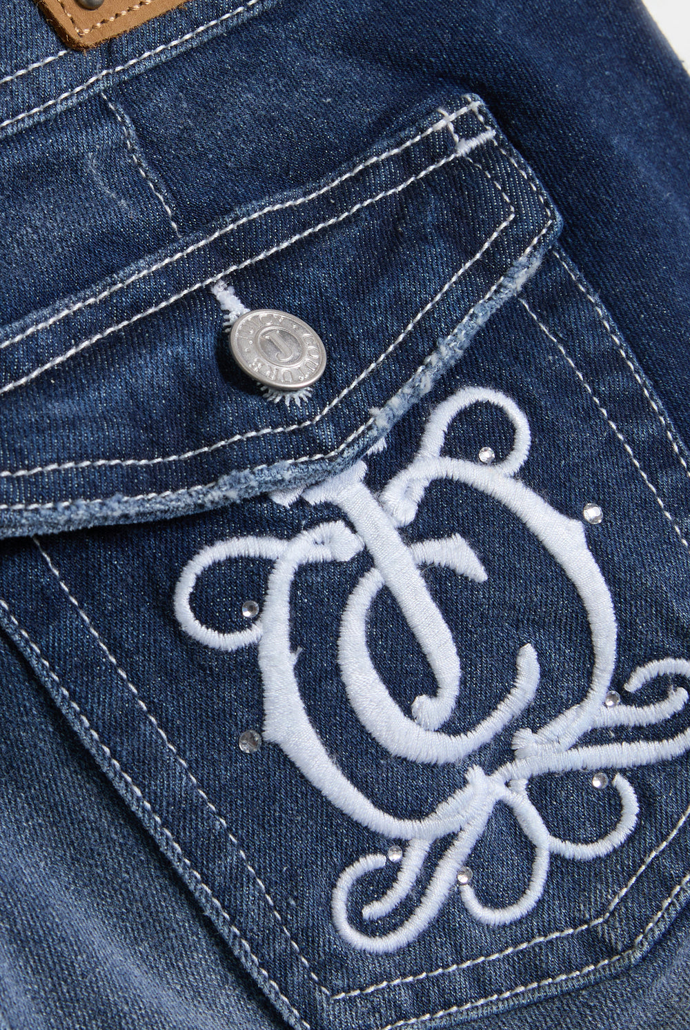 Displays a model wearing the 'Juicy' branded mid wash low rise flare embroidered jeans featuring the juicy logo