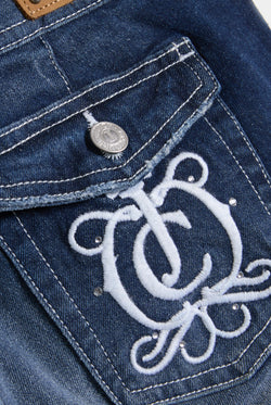 Displays a model wearing the 'Juicy' branded mid wash low rise flare embroidered jeans featuring the juicy logo