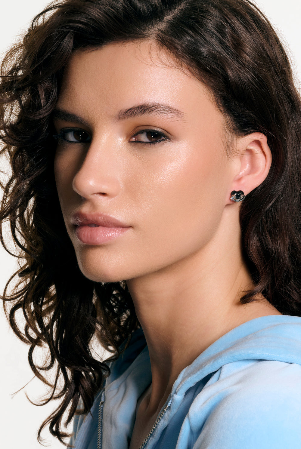 Displays a model wearing the Silver Tone 'Juicy' branding enamel icon heart stud earrings 