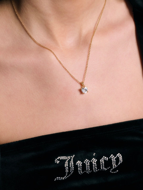 Displays a model wearing the 'Juicy' Gold Tone Solitaire Crystal Heart Pendant