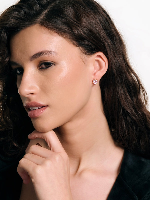 Displays a model wearing the 'Juicy' Gold Tone Solitaire Crystal Heart Stud Earring