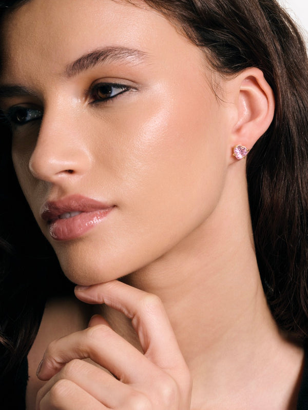 Displays a model wearing the 'Juicy' Gold Tone Solitaire Crystal Heart Stud Earring